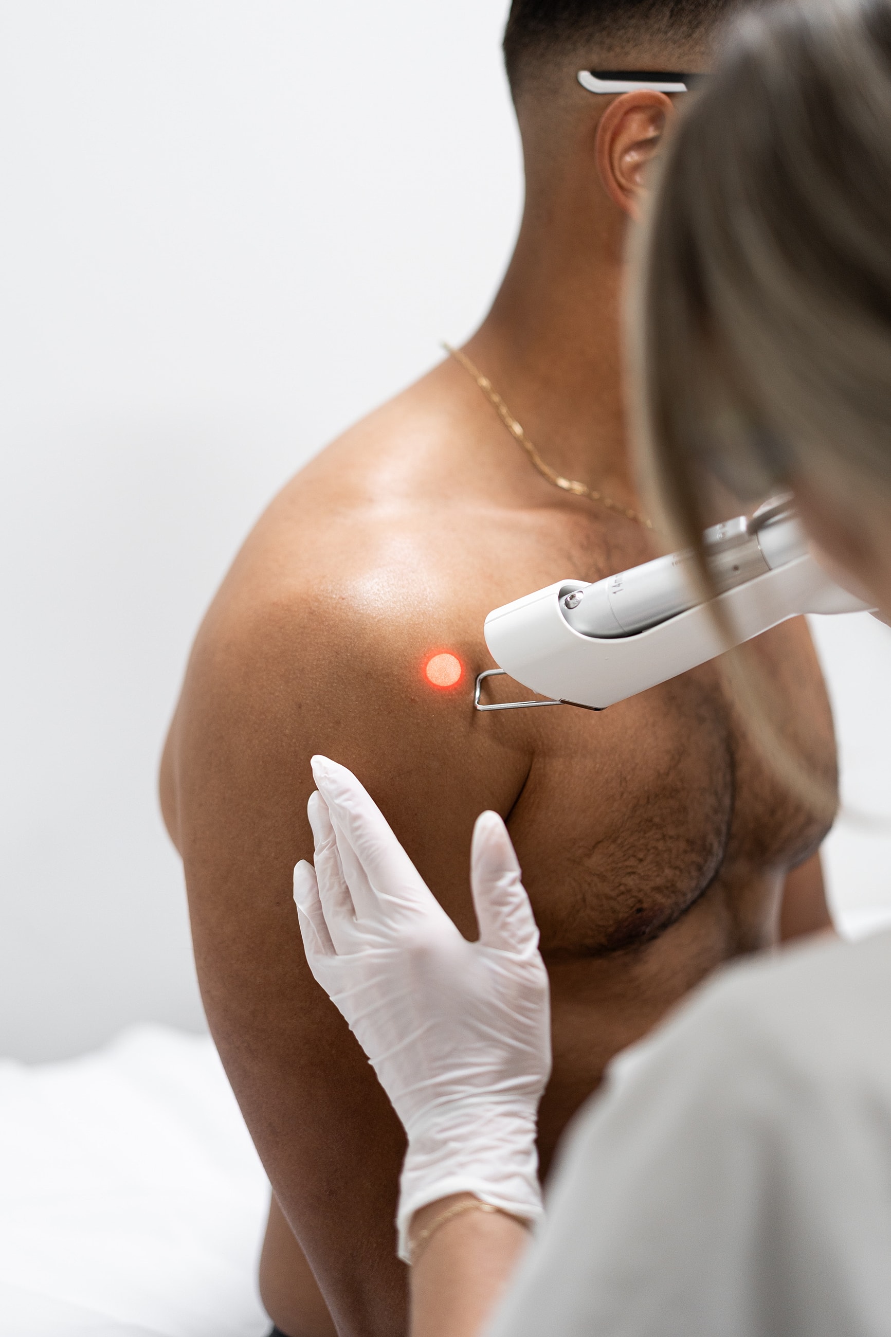Laser treatment on a man's shoulder.