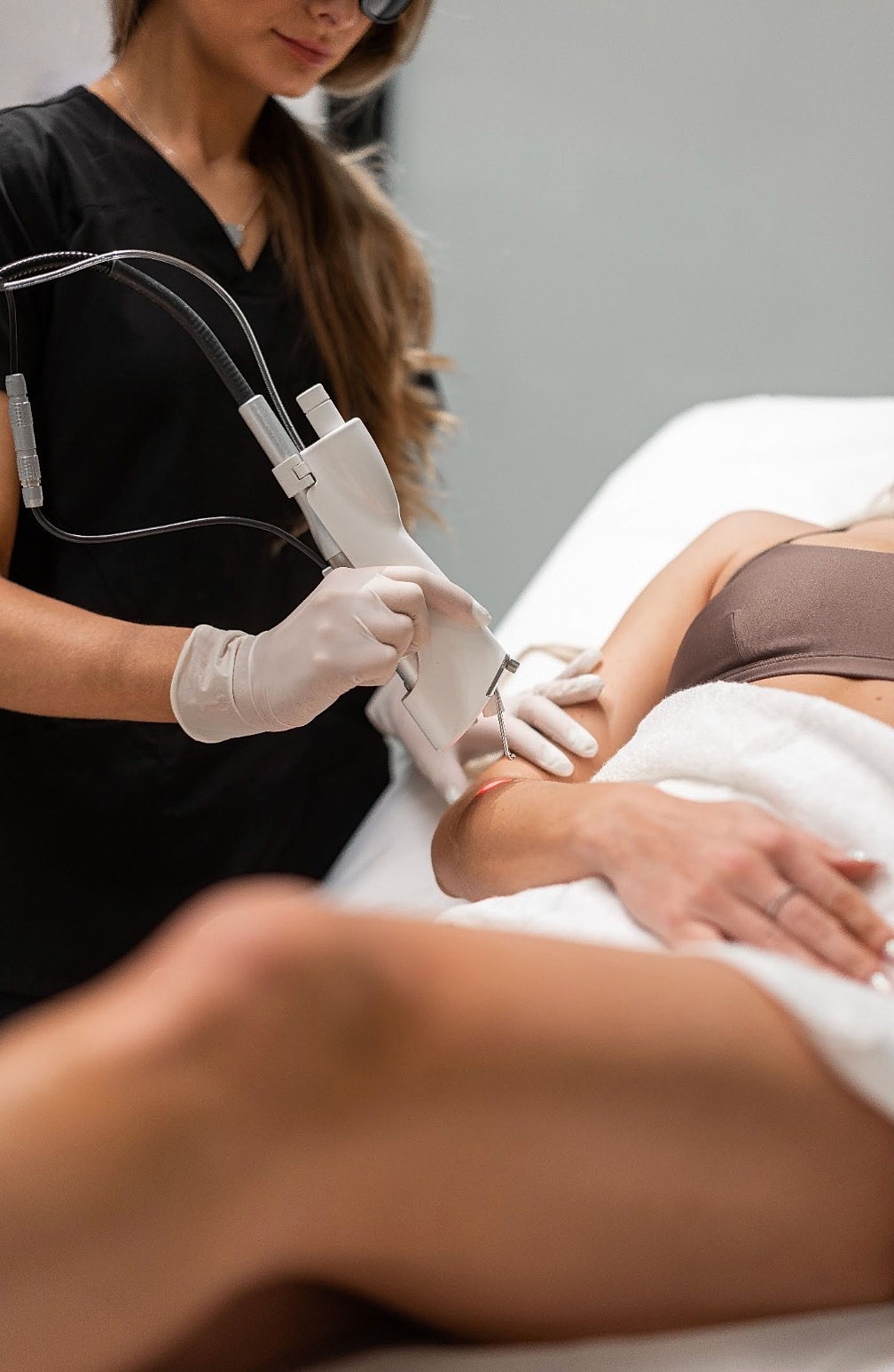 Woman receiving laser treatment on her ar at Kalon