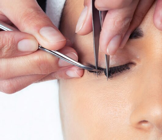 shot-cosmetologist-doing-eyelash-extension-procedure-woman-white-background